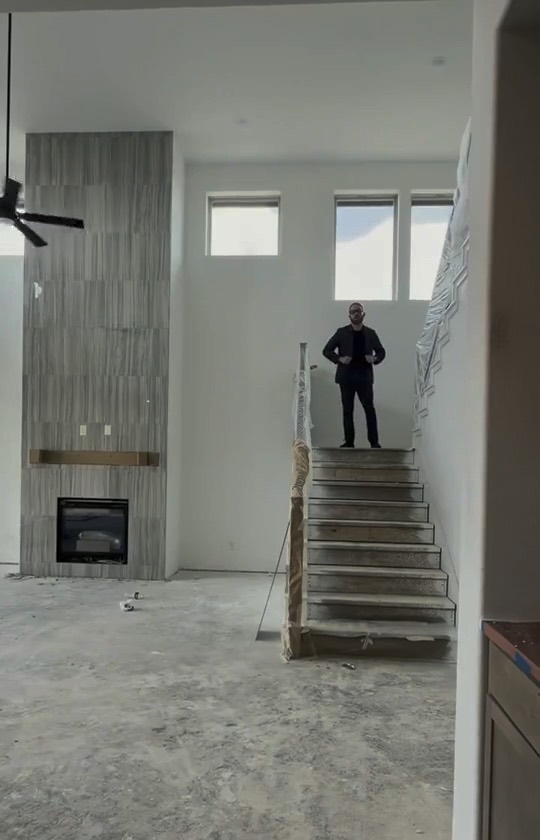 Me at the top of the stairs in a new build that's still being finished