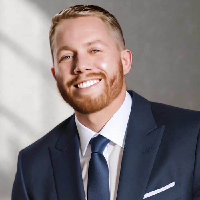Me in a navy suit, smiling, in window light